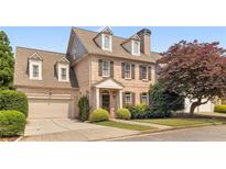 Charming brick two-story home with a well-manicured lawn and attached two-car garage at 1121 Vinings Grove Se Way, Smyrna, GA 30082