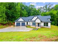Beautifully landscaped single-story home with a two-car garage and a long driveway at 5264 Prestley Crossing Ln, Douglasville, GA 30135