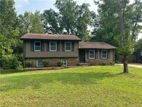 Split level home with green lawn, and brick/vinyl siding at 8415 Magnolia Dr, Jonesboro, GA 30238