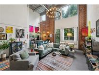 Bright living room boasts exposed brick walls, large windows, modern lighting, and stylish contemporary furnishings at 195 Arizona Ne Ave # 197, Atlanta, GA 30307
