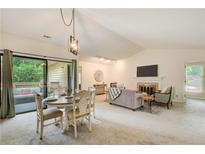 Bright living room featuring vaulted ceilings, fireplace, and sliding glass doors to a deck at 202 Garden Ct, Atlanta, GA 30328