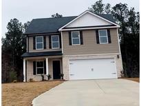Charming two-story home featuring a two-car garage, neutral siding, and black shutters on a cloudy day at 30 Barton Ln, Covington, GA 30016