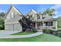 Charming two-story home with a manicured lawn, two-car garage, and inviting front porch at 306 Mill Rdg, Canton, GA 30114