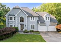 Beautiful two-story home featuring a manicured lawn and a two-car garage at 3525 Stone Cliff Way, Woodstock, GA 30189