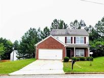 Charming two-story home featuring a brick facade, well-maintained lawn, and an attached two car garage at 6902 Malvern Ct, Stonecrest, GA 30038