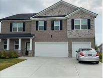 Beautiful two-story home featuring a brick and stone facade, and a two-car garage at 3378 English Elm Way, Loganville, GA 30052