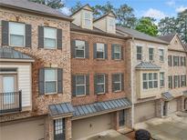 Beautiful brick townhome with gray shutters and attached garage in a desirable neighborhood at 262 Bell Grove Ln, Suwanee, GA 30024