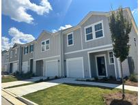 Charming townhomes feature attached garages, well-manicured lawns, and attractive color schemes at 307 Winton Way, Villa Rica, GA 30180