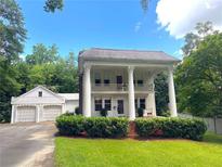 Stately two-story white home featuring large columns and a charming two-car detached garage at 1242 Star Ne Dr, Brookhaven, GA 30319