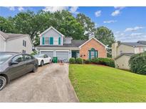 Charming home featuring a landscaped yard, attached two-car garage, and welcoming front entrance at 4945 Penscot Way, Stone Mountain, GA 30088