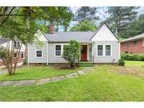 Charming single-story home with landscaped yard and a classic red front door at 1098 Cascade Sw Cir, Atlanta, GA 30311