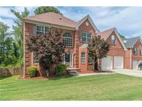 Charming brick two-story home with mature trees and a well-manicured lawn at 118 Surge Stone Ln, Stockbridge, GA 30281