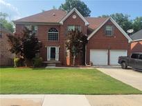 Charming two-story brick home with a well-manicured lawn and attached two-car garage at 118 Surge Stone Ln, Stockbridge, GA 30281