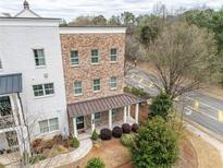 Charming multi-story townhouse with brick and painted siding, and a welcoming covered porch at 2026 Forte Lane, Alpharetta, GA 30009
