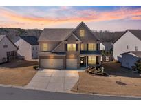Stunning two-story home featuring a brick facade, well-manicured landscaping, and a spacious three-car garage at 5915 Partners Pass, Cumming, GA 30028