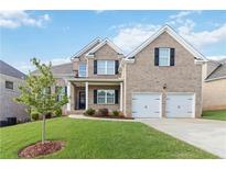 Charming two-story brick home with a well-manicured lawn and a two-car garage at 2031 Broadmoor Way, Fairburn, GA 30213