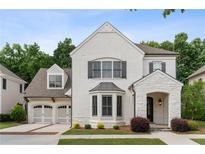 Charming two-story white brick home with a manicured lawn, arched entry, and attached two-car garage at 10580 Grandview Sq, Johns Creek, GA 30097