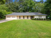 Charming single-story home featuring a spacious front yard and an attached two-car garage at 4062 Plantation Dr, Marietta, GA 30062