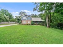 Charming two-story home with a metal roof, landscaped yard, and a welcoming front porch at 48 Old Canton Ne Rd, Cartersville, GA 30121