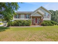Charming home featuring a landscaped front yard with lush green lawn and covered entryway at 47 Powder Springs St, Hiram, GA 30141