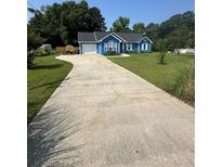 Charming blue home with a long concrete driveway and well-manicured lawn at 160 Springdale Ct, Newborn, GA 30056