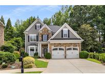 Charming two-story home with stone accents, gray siding, manicured lawn, and a two-car garage at 3699 Canyon Ridge Ne Ct, Brookhaven, GA 30319