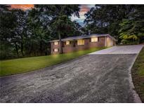 Charming brick home with a long driveway and well-manicured lawn, set amongst mature trees at 6243 David Sw Ln, Mableton, GA 30126