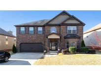 Charming brick two-story home featuring an attached garage and manicured lawn at 817 Nevis Way, Mcdonough, GA 30253