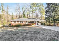 Charming single-story brick home featuring a covered carport and a well-maintained front yard at 3073 Henderson Mill Rd, Atlanta, GA 30341