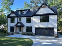 Beautiful white brick home with black trim and a well-manicured lawn at 4955 Chamblee Dunwoody Rd, Dunwoody, GA 30338