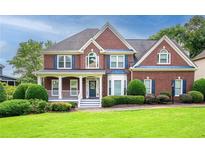 Beautiful two-story brick home featuring a manicured lawn, inviting porch and blue shutters at 1409 Echo Mill Dr, Powder Springs, GA 30127