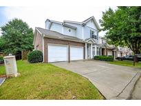 Charming two-story home featuring a brick and siding facade, a two-car garage, and a well-maintained lawn at 2594 Laurel Nw Cir, Atlanta, GA 30311