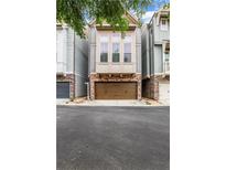 Charming townhome featuring stone accents and a two-car garage with inviting curb appeal at 3005 Devoncroft Se St, Smyrna, GA 30080