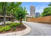 Townhomes on a street, lined with trees and landscaping, near a downtown area at 384 16Th Nw St # 1, Atlanta, GA 30363