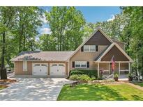 Charming exterior view of a two-story home with a large garage and well-manicured lawn at 890 Lake Dr, Snellville, GA 30039