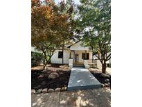 Inviting front yard of a renovated home with mature trees and a modern walkway leading to the entrance at 1766 W Lyle W Ave, College Park, GA 30337