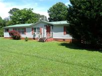 Charming single-story home with a green metal roof and well-maintained front yard at 2900 Hitt Rd, Cumming, GA 30041