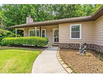 Charming home featuring a manicured lawn, walkway to the front door, and mature trees in a tranquil setting at 4655 Barnes Ct, Loganville, GA 30052