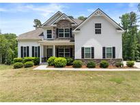 Beautiful home featuring stone accents, a covered porch, lush landscaping, and a well-manicured lawn at 2855 Pilgrim Mill, Cumming, GA 30041