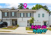 Charming townhome with a one-car garage and a well-maintained front yard and colorful flowers at 3481 Lakeview Crk, Lithonia, GA 30038