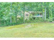 Charming home exterior nestled among trees with a well-manicured lawn at 911 White Stag Ln, Canton, GA 30115