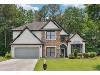Charming home with a stone and stucco facade, complemented by a well-manicured lawn and lush landscaping at 9811 Spyglass Dr, Villa Rica, GA 30180