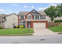Charming two-story home with brick facade, two-car garage, manicured lawn and inviting curb appeal at 1657 Bradmere Ln, Lithia Springs, GA 30122