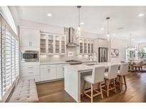 Modern kitchen features an island, stainless appliances, hardwood floors, and pendant lighting at 4202 Deming Cir, Sandy Springs, GA 30342