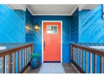 Inviting entrance featuring a vibrant orange door, blue siding, and a charming wooden porch at 2139 Logan Dr, Jonesboro, GA 30236