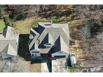 An aerial view of a multi-story home with a large roof, surrounded by trees and ample outdoor space at 3265 Greenhill Ct, Villa Rica, GA 30180