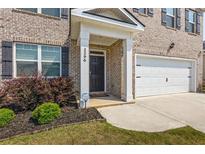 Inviting front entrance with a black door, lush landscaping, and a Ring doorbell at 2296 Waycross Ln, Dacula, GA 30019