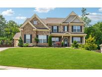 Inviting two-story brick home with a manicured lawn, black shutters, and charming front porch at 422 Silver Brook Dr, Woodstock, GA 30188