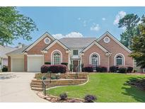 Beautiful brick home with a well-manicured lawn and a two-car garage at 10280 Medridge Cir, Johns Creek, GA 30022
