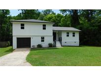 Charming two-story home features a fresh exterior paint, attached garage, and well-maintained front lawn at 9148 Homewood Dr, Riverdale, GA 30274